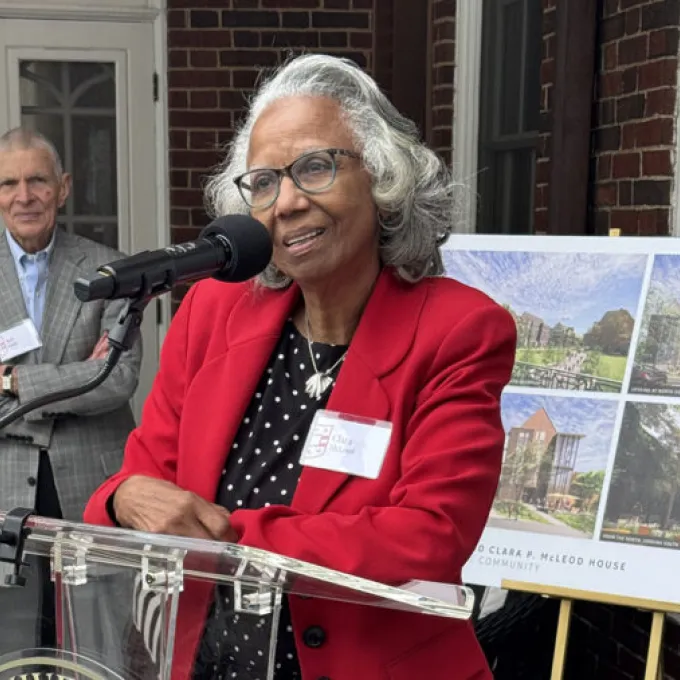Clara Mcleod stands at a podium, speaking